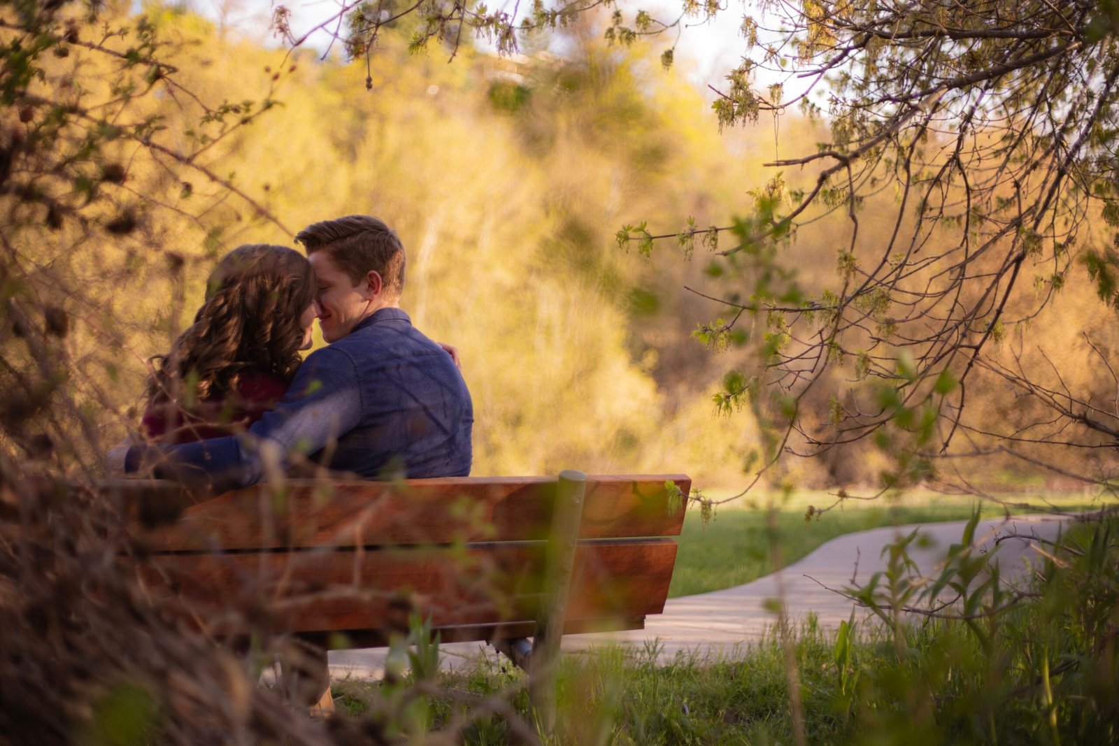 Home A couple enjoying a cozy moment on a park bench surrounded by nature.